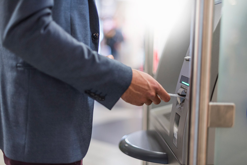 Woman withdrawaling cash from ATM - image